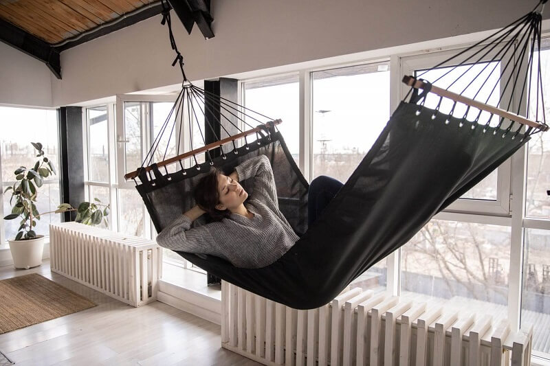 A woman happily laying on a hammock