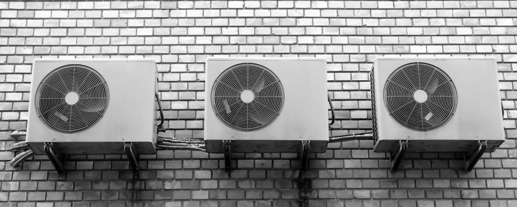 Three outdoor AC units attached to a wall