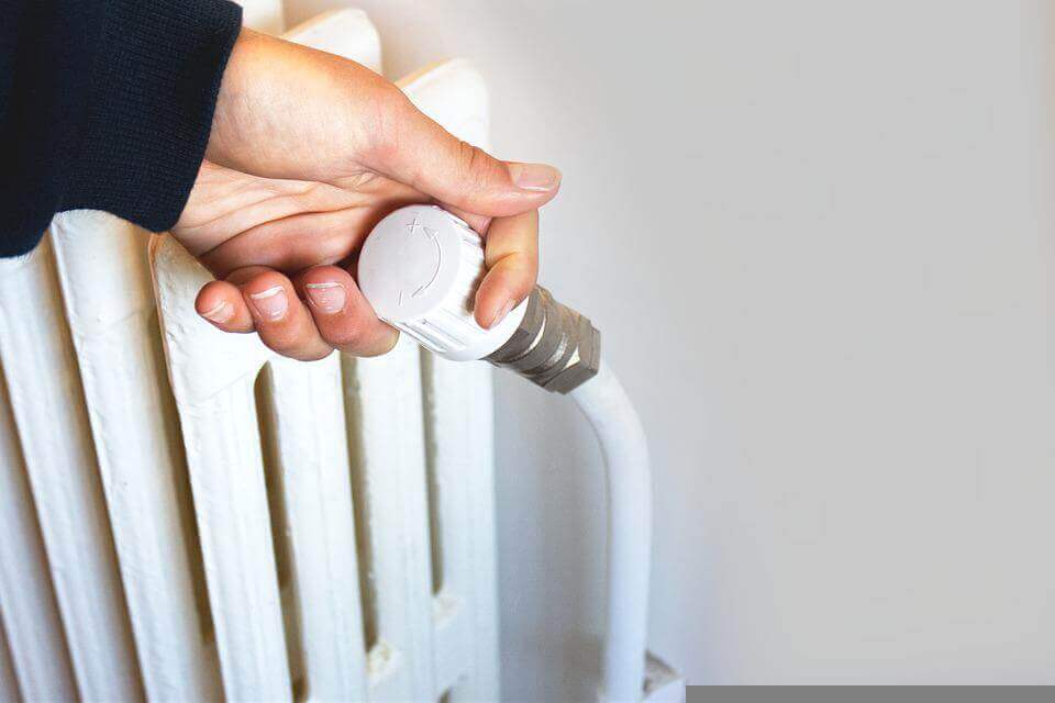 A person adjusting a radiator